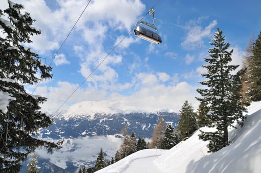Empty ski lift in beautiful winter snowy mountain landscape (resort in Alps)