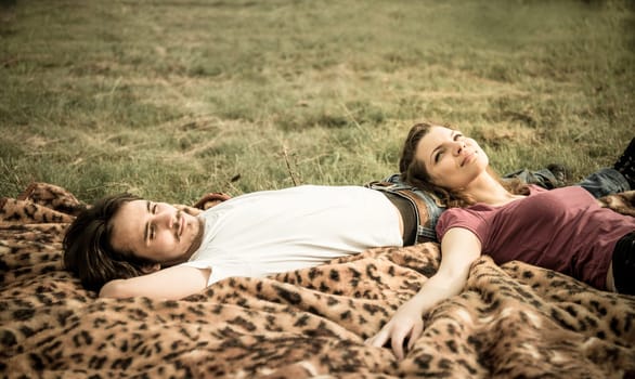 Young couple relaxing outdoor in nature (woman lies on man)