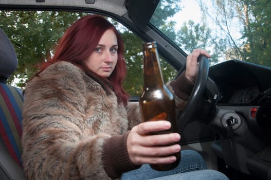 drunk woman driving car with beer in hand