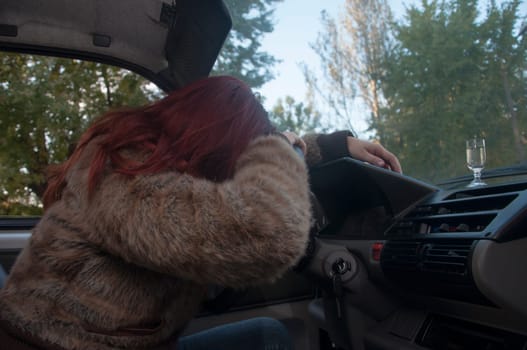 drunk woman driving car with vodka in hand