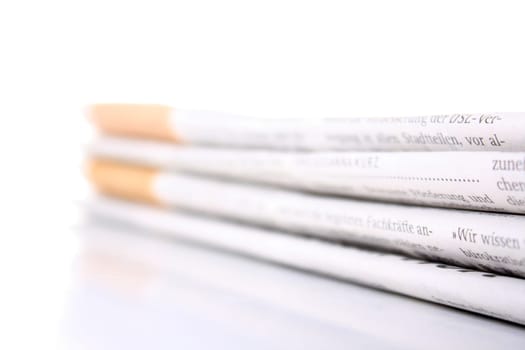 several newspapers stacked with white background