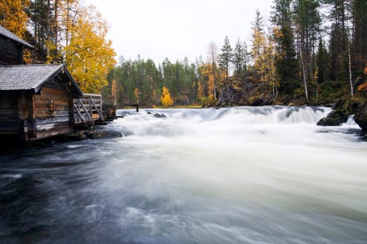 Fast flowing river flow and aged unemployed watermill