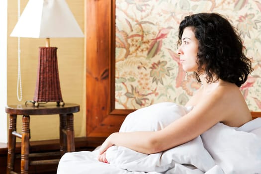 Woman under soft cover look to window side