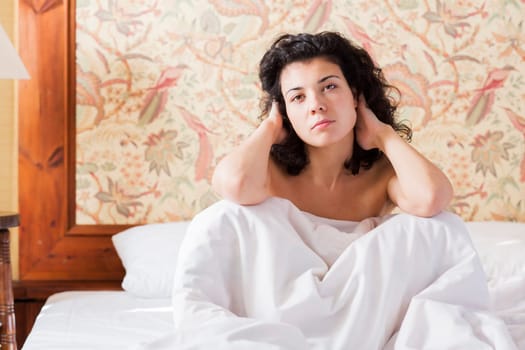 Woman adjust hairs in bed after restless night