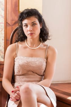 Woman on wooden chair with pretty serious look
