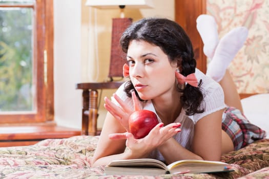 Woman in schoolgirl cross arms over ripe apple