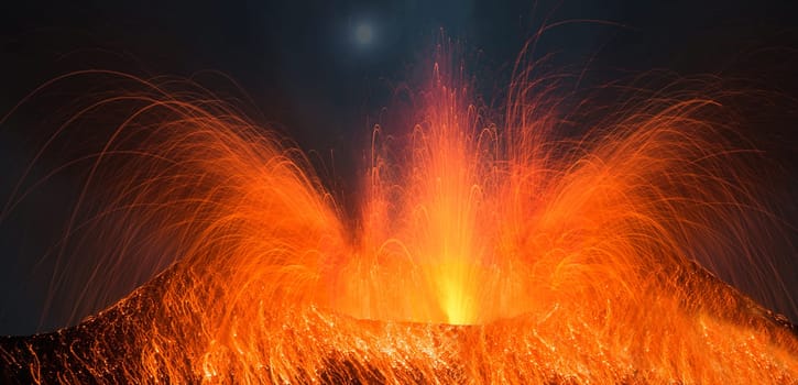 Volcano erupting at night with a very strong eruption