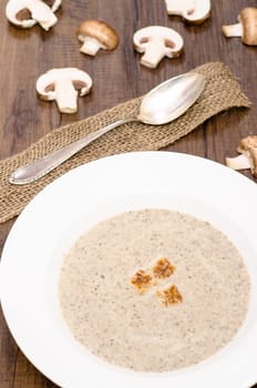 Mushroom soup with mushrooms in a white plate with spoon