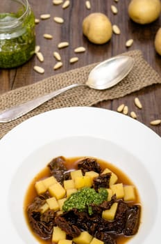 Potato soup with tomatoes and pesto in portrait format