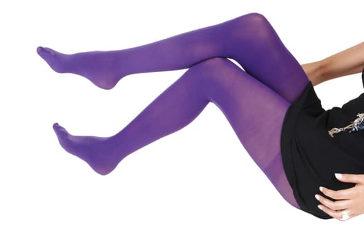 The legs of a slim woman sitting on the floor in purple tights in closeup.for white background..