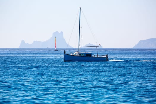 Es Vedra Ibiza silhouette with boats view from Formentera in Balearic islands