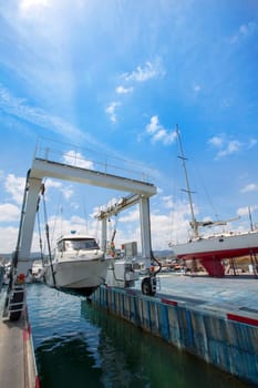 Boat crane working with boats in Mediterranean