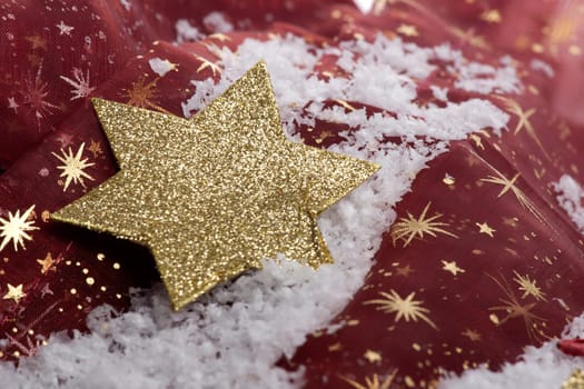 golden poinsettia on artificial snow with decoration