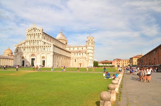 Tourists on Square of Miracles visiting Leaning Tower of Pisa, Italy.