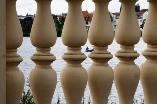 The photograph of pillars of a wall on a lake