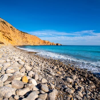 Ibiza Cala Jondal Beach with rolling stones in san Jose at Balearic Islands