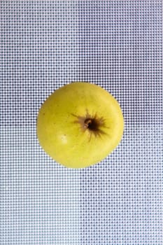 Green apple on a placemat, background.