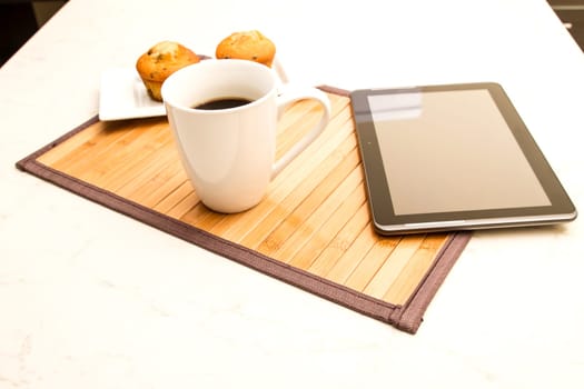 Vanilla with chocolate chips Muffins with  a cup of coffee meanwhile using the tablet..