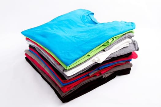 A pile of folded T shirts .