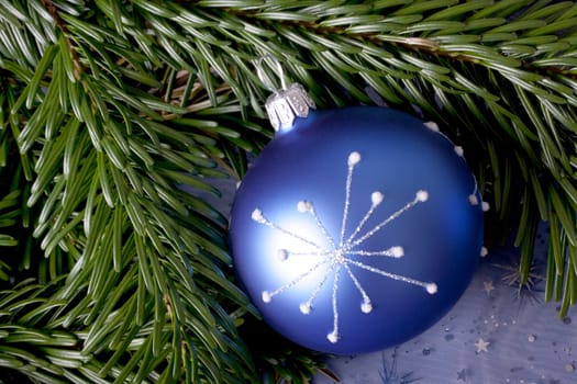 blue Christmas bauble with white pattern and fir branch