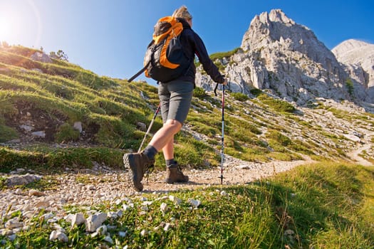 Young woman on a sunny day hiking in high mountains