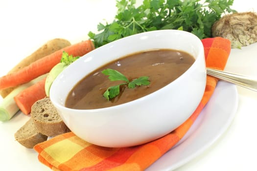 a white bowl with oxtail soup and parsley
