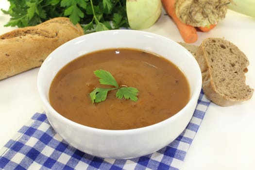 a white bowl with oxtail soup and parsley