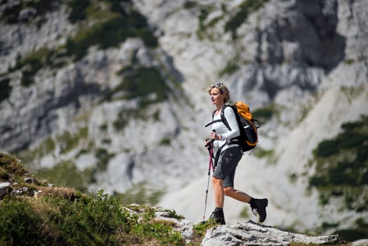 Young woman on a sunny day hiking in high mountains