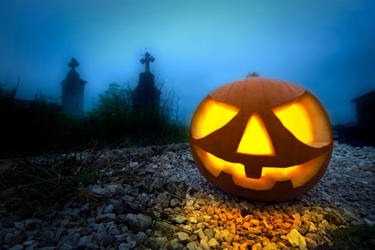 Scary halloween pumpkin in the dark graveyard at night