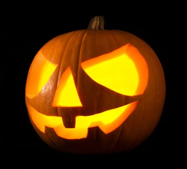 Scary old jack-o-lantern on black background close up