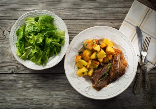 Roasted meat and potatoes with salad close up shoot