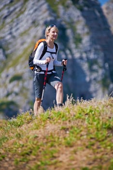 Young woman on a sunny day hiking in high mountains