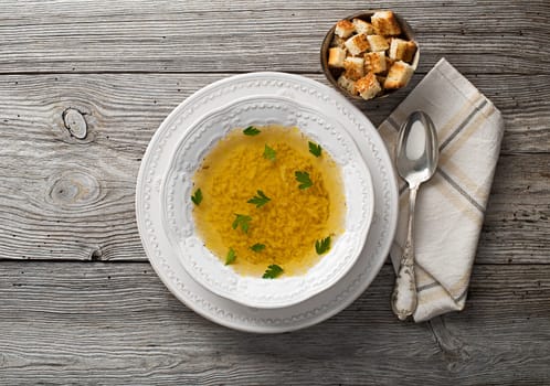 Fresh chicken or beef soup on wooden background overhead shoot