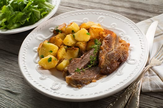 Roasted meat and potatoes with salad close up shoot