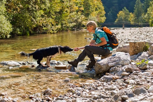 Young woman with dog on a sunny day hiking