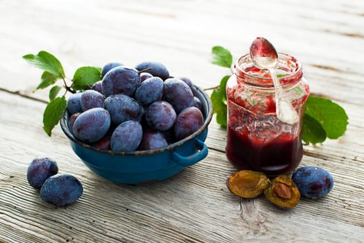 Plums and marmelade on wooden background close up