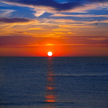 Sunset at Mediterranean sea with orange sky and sun reflection