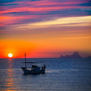 Ibiza sunset Es Vedra view and menorquina fisherboat from Formentera orange sky