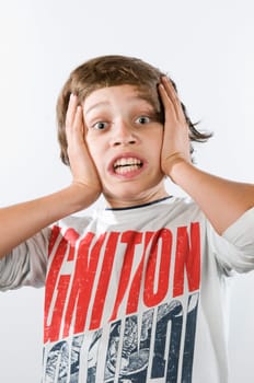 Head-and-shoulder portrait of a 13-year-old boy against a white background with palms pressed to his cheeks stressed into the camera