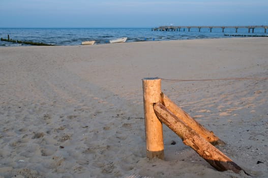 flat fence post with tensioned wire on the sandy beach near the city of Bansin / Usedom / Germany in summer