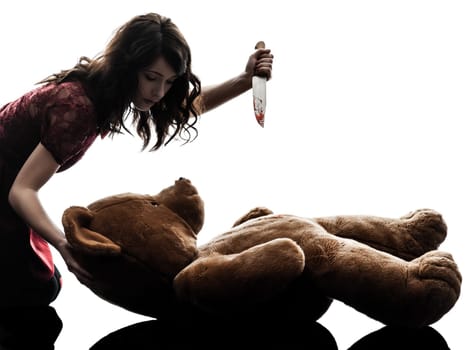 one caucasian strange young woman killing her teddy bear  in silhouette white background