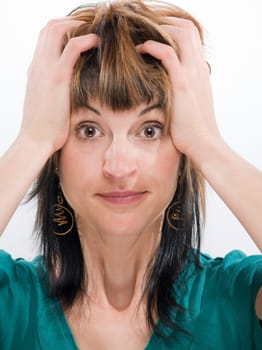 Head-and-shoulder shot of a young woman tearing her hair looking into the camera