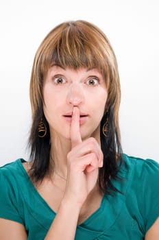 Head-and-shoulder photograph of a young woman holding her finger in front of her mouth (gesture