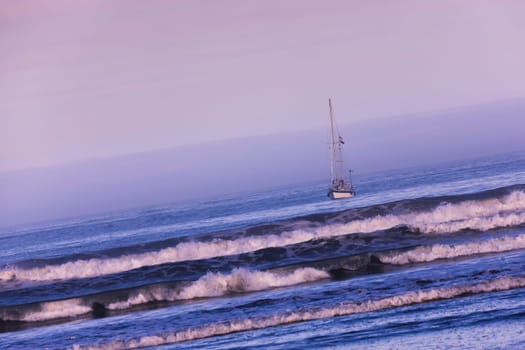 Sailing boat on the ocean at dawn.