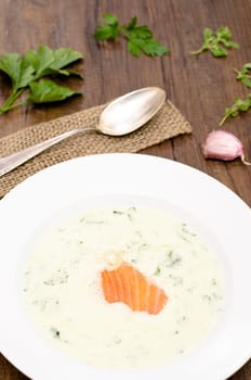 Soup with green herbs and smoked salmon in portrait format