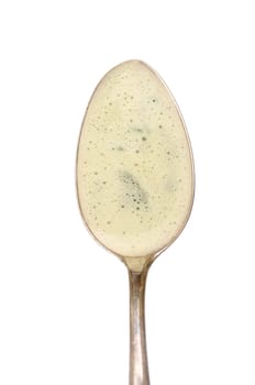 Spoon with foam of green herb soup with marjoram