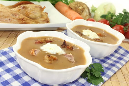 white bowls with duck soup and cream