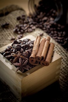 Black roasted coffee beans in a small burlap sack