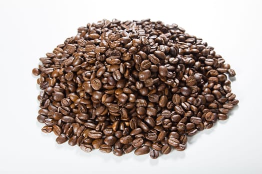 Black roasted coffee beans in a small burlap sack
