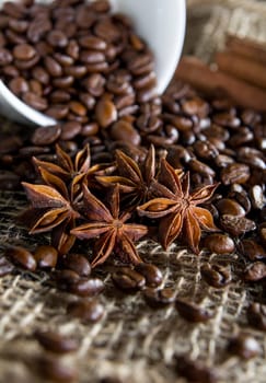 Black roasted coffee beans in a small burlap sack
